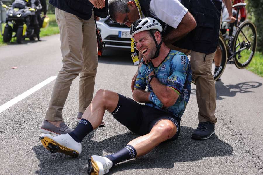 Team DSM - Firmenich's French rider Romain Bardet receives medical attention after a crash during the 14th stage