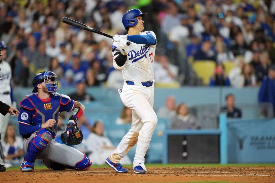 Los Angeles Dodgers designated hitter Shohei Ohtani hits a two-run home run in the sixth inning as Texas Rangers catcher Jonah Heim watches