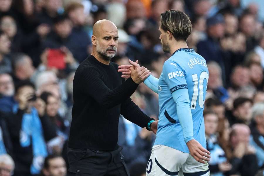 Manchester City manager Pep Guardiola shakes hands with Jack Grealish