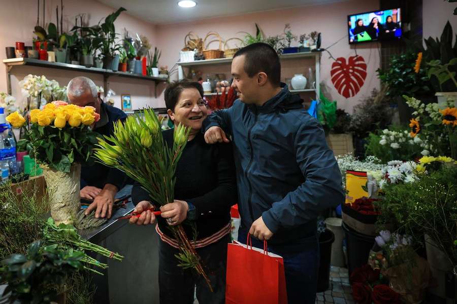 Vice-campeão do mundo de natação, Francisco Montes, de 24 anos e com trissomia 21, conversa com Ilda Maria, florista, perto da pizaria onde trabalha na Foz do Douro, no Porto