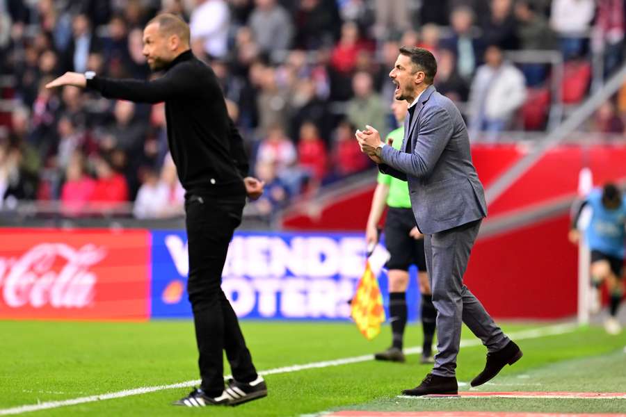 Ajax-coach langs de lijn naast zijn collega-coach Julio Velazquez