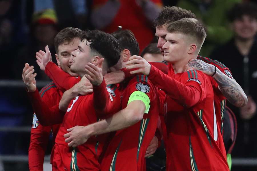 Neco Williams celebrates with team-mates after scoring Wales' second goal