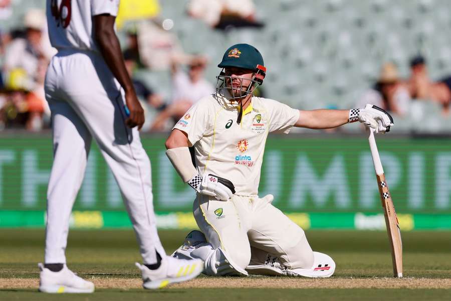Australia's Travis Head kneels on the ground after he is run out by the West Indies