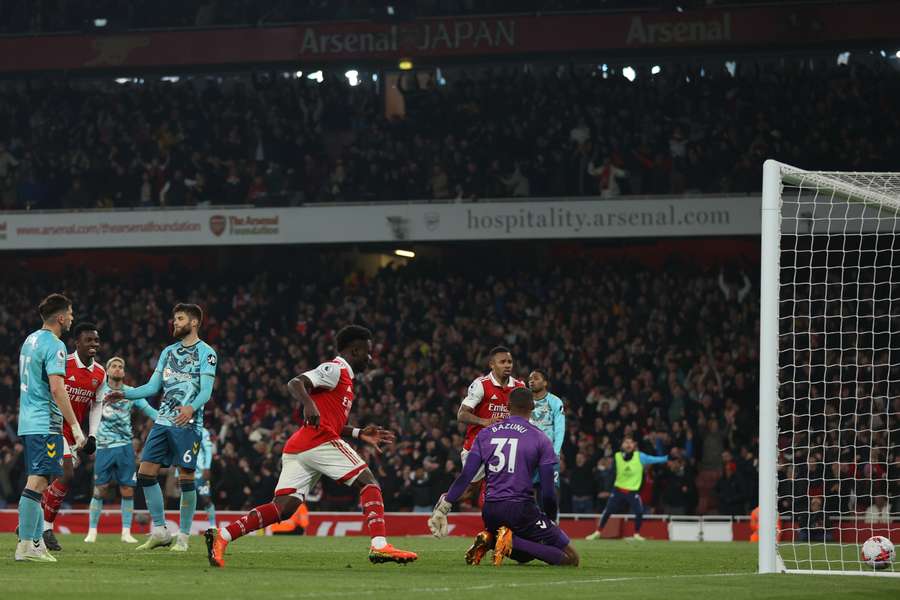 El centrocampista inglés del Arsenal Bukayo Saka corre a recoger el balón tras marcar su tercer gol