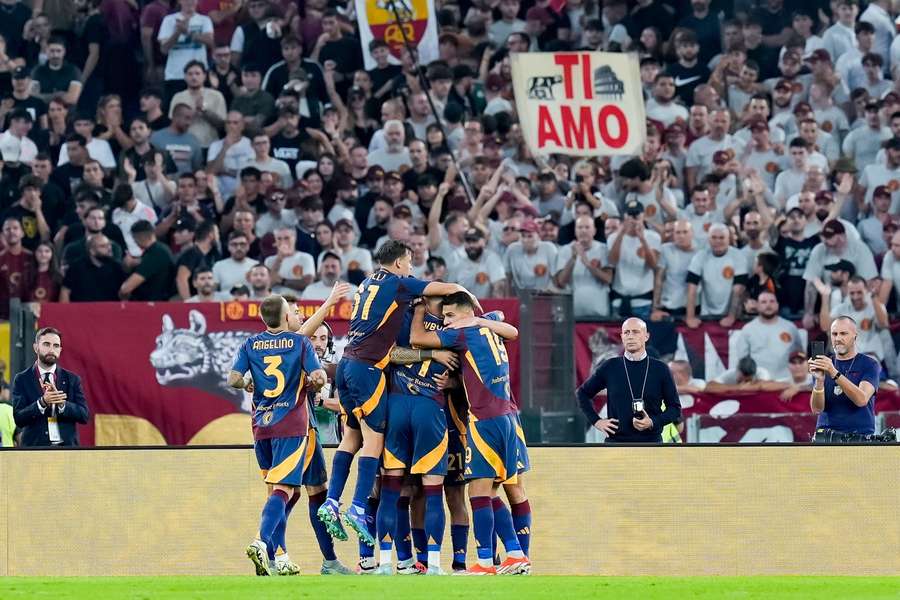 Roma players celebrate after scoring against Udinese