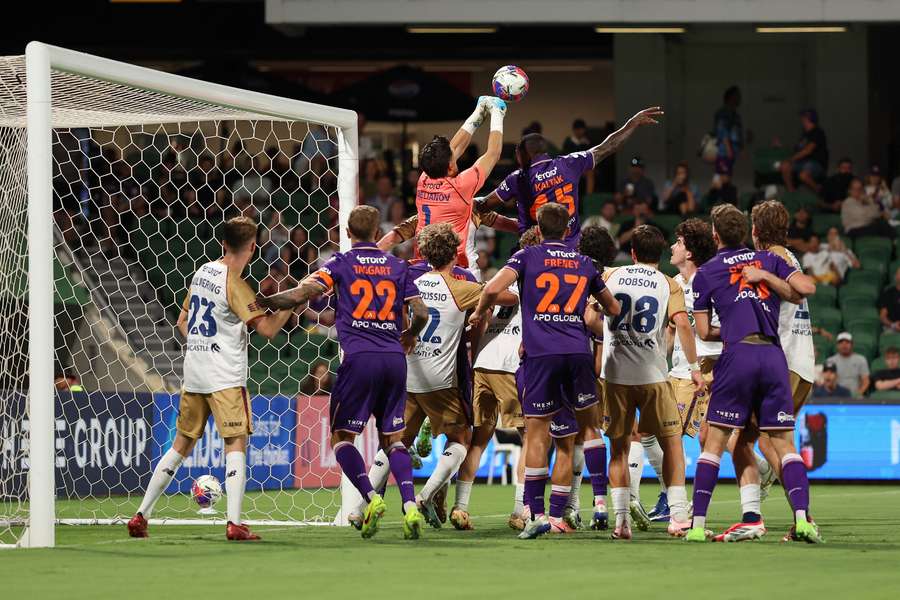 James Delianov commits to one of his three punching clearances against Perth at the weekend.