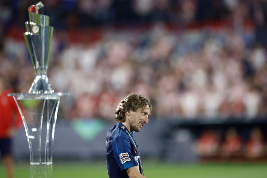 Luka Modric reacts as he walks past the UEFA Nations League trophy