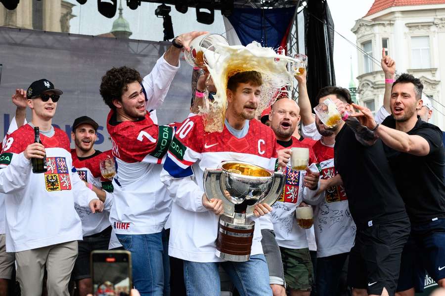 Kapitán hokejových majstrov sveta Roman Červenka dostáva pivnú sprchu od Davida Špačka.