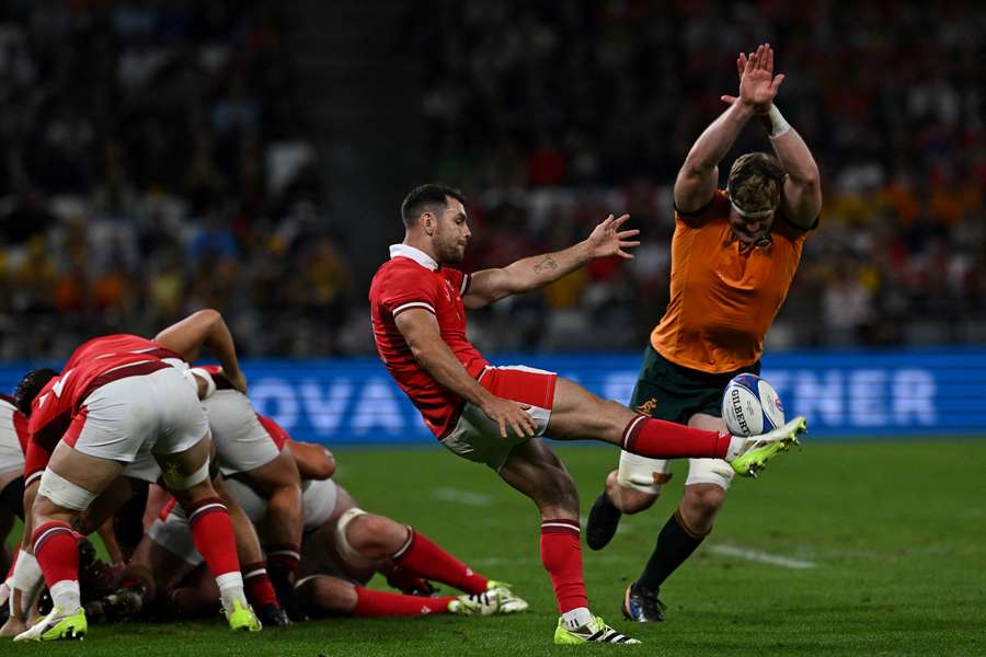 Wales' scrum-half Tomos Williams (L) kicks the ball in front of Australia's lock Matt Philip