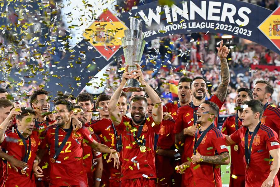 O defesa espanhol Nacho Fernandez (C) segura a Taça da Liga das Nações da UEFA enquanto os jogadores espanhóis festejam no pódio 