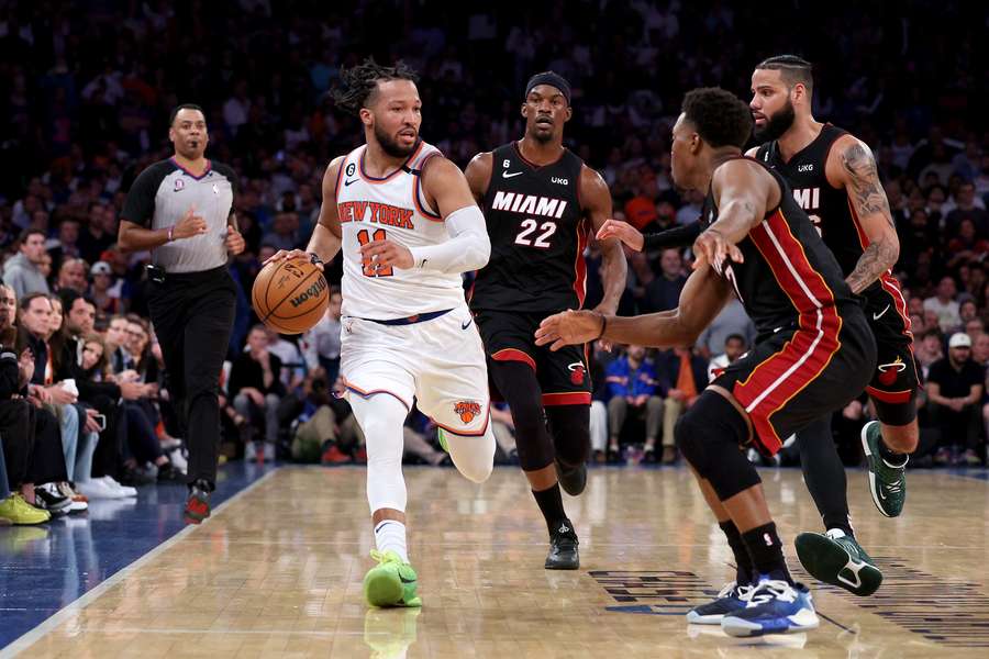 Jalen Brunson of the New York Knicks dribbles against Jimmy Butler, Caleb Martin and Kyle Lowry of the Miami Heat