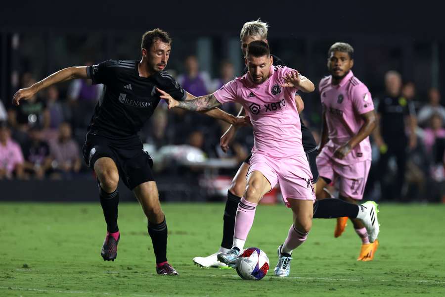 Inter Miami forward Lionel Messi (R) fights for the ball with Nashville defender Jack Maher