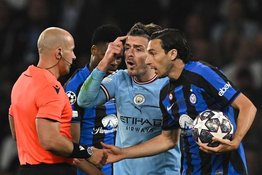 Matteo Darmian and Jack Grealish remonstrate with referee Szymon Marciniak