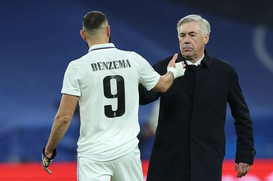 Carlo Ancelotti choca la mano con Karim Benzema.