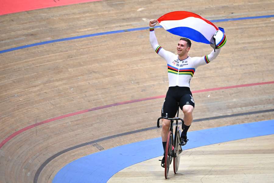 Harrie Lavreysen vier een wereldtitel met de Nederlandse vlag boven zijn hoofd