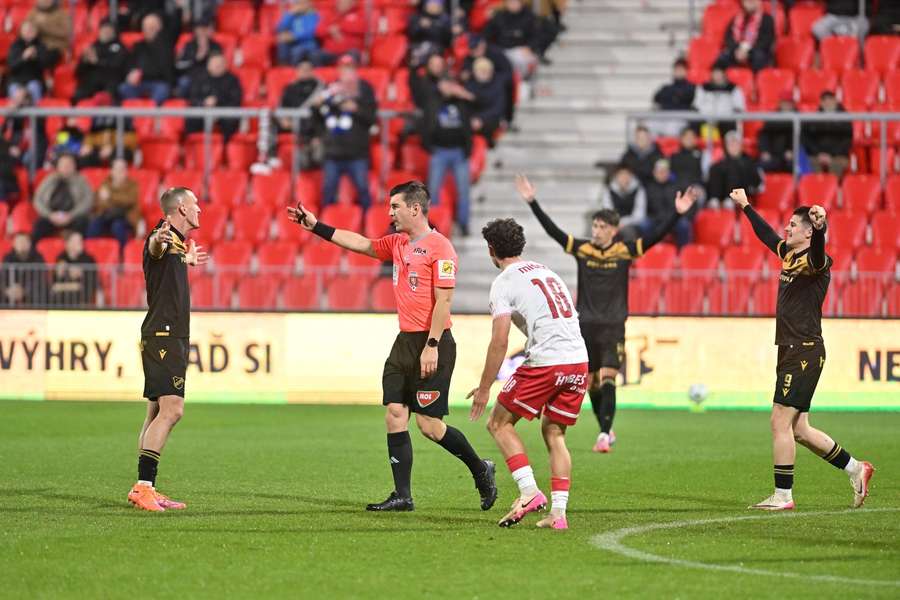 Hráči Baníku slaví gól, pardubický Štěpán Míšek marně protestuje u rozhodčího. Hráči Baníku slaví gól, pardubický Štěpán Míšek marně protestuje u rozhodčího.