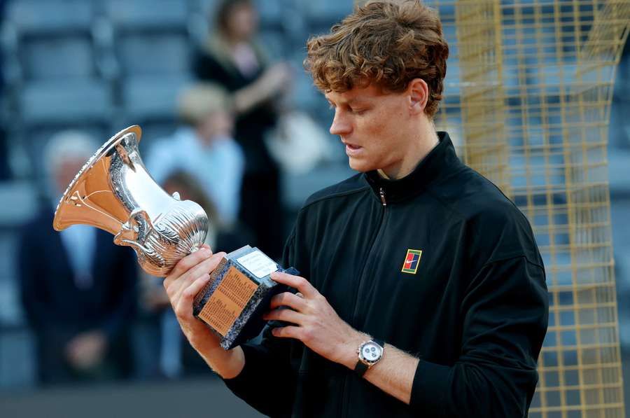Jannik Sinner contempla il trofeo