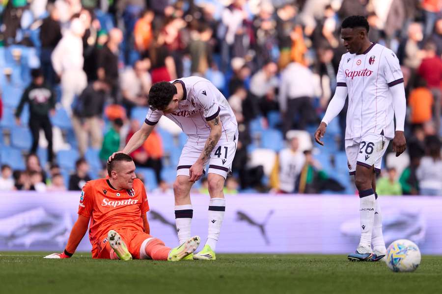 Lukasz Skorupski a terra consolato dai suoi compagni di squadra