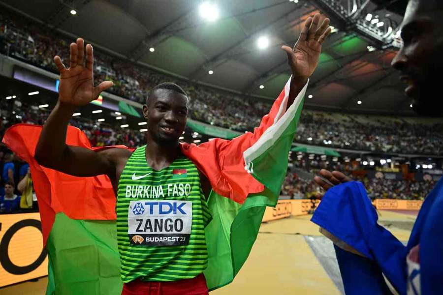 Gold medalist Hugues Fabrice Zango celebrates with his national flag after the men's triple jump final