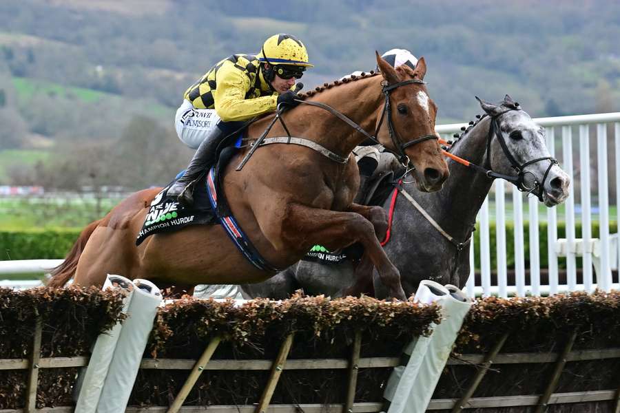 Paul Townend (L) and State Man take the final hurdle ahead of jockey Jack Kennedy (R) on Irish Point on the way to victory in the Champion Hurdle
