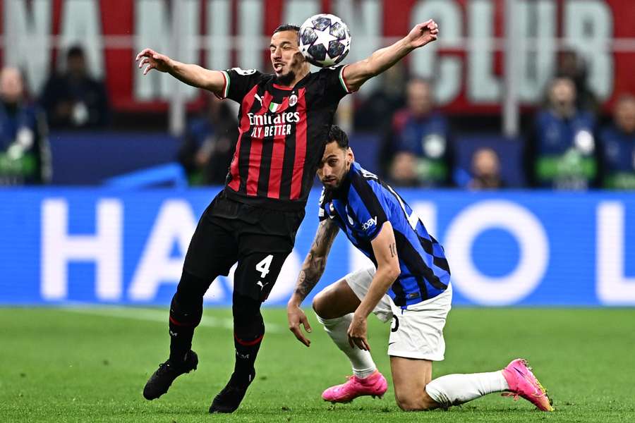 AC Milan's Algerian defender Ismael Bennacer (L) and Inter Milan's Turkish midfielder Hakan Calhanoglu go for the ball