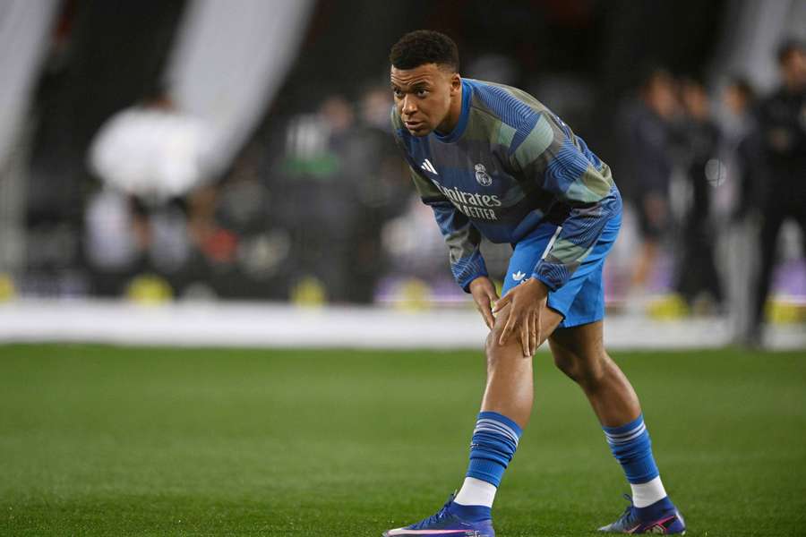 Mbappé, tocándose la rodilla izquierda en un calentamiento