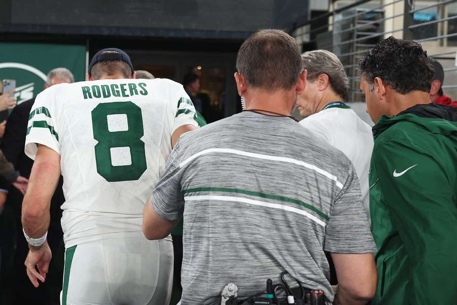 Aaron Rodgers met gebogen hoofd van het veld enkele minuten na zijn debuut voor de Jets