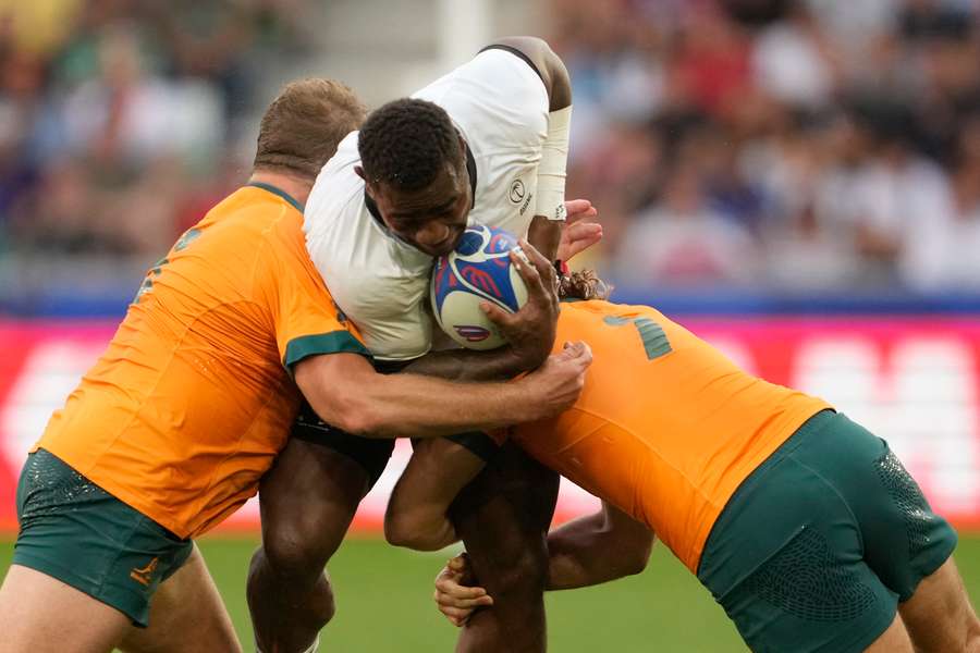 Fiji's Josua Tuisova wordt getackeld door twee Australiërs