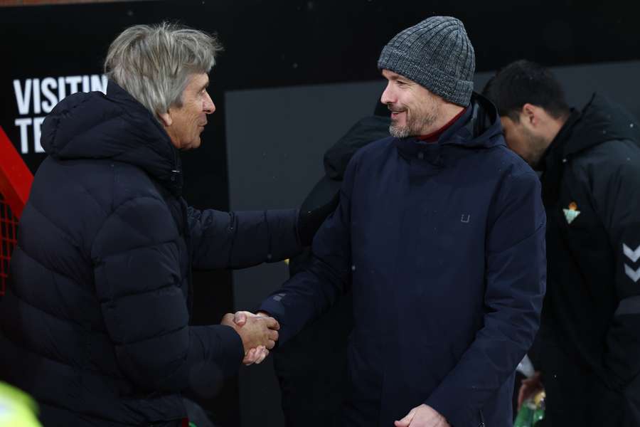 Manchester United's Dutch manager Erik ten Hag (R) greets Real Betis' Chilean coach Manuel Pellegrini (L)