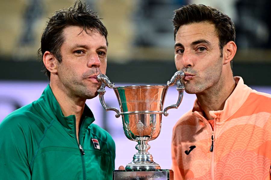 Argentina's Horacio Zeballos (left) and Spain's Marcel Granollers kiss their trophy after winning their men's doubles final