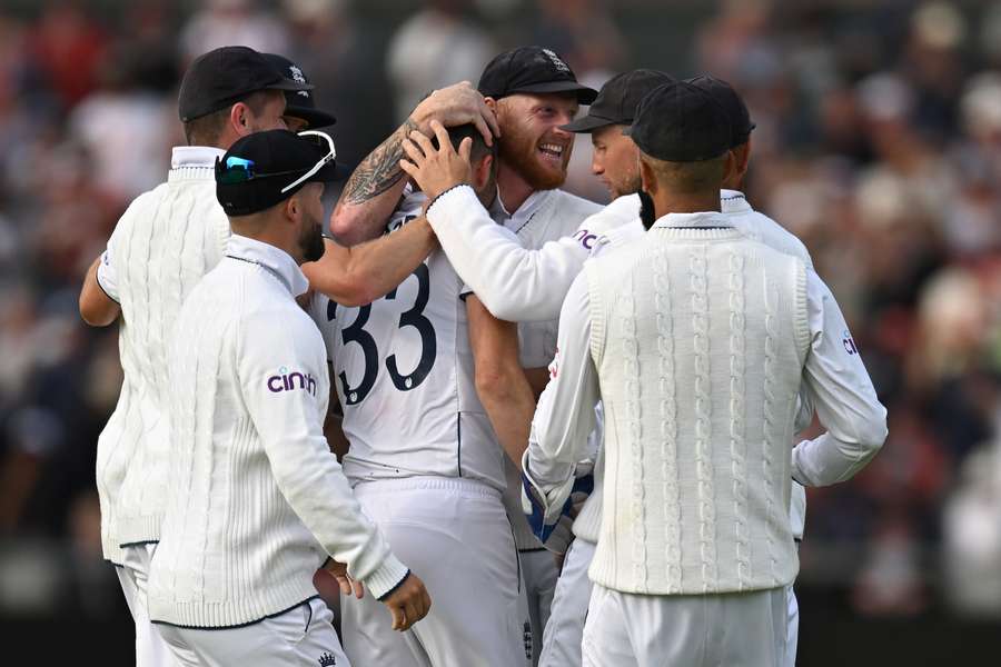 Mark Wood is congratulated by teammates after taking the wicket of Australia's Travis Head