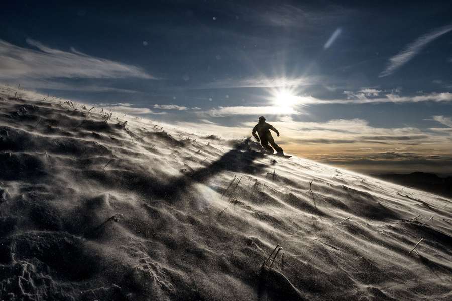 Un refugiado afgano disfruta sobre la nieve.