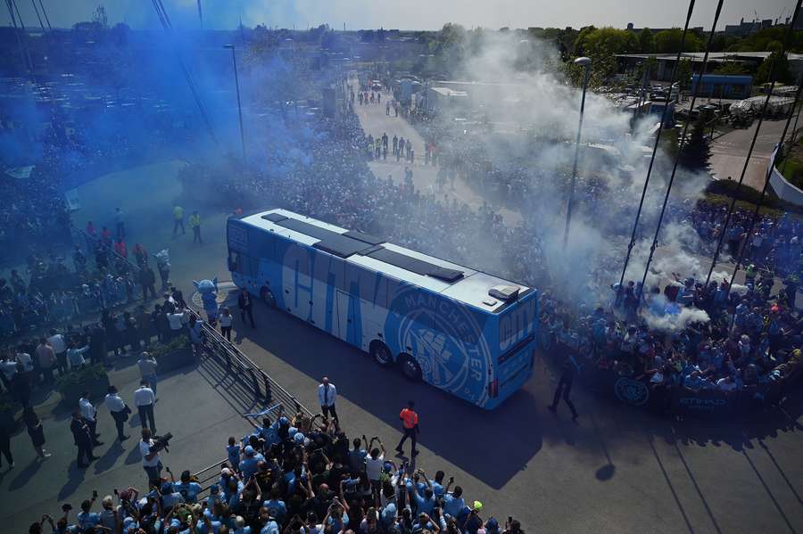 Fans react as Manchester City's team bus arrives ahead of the English Premier League football match between Manchester City and Chelsea at the Etihad Stadium