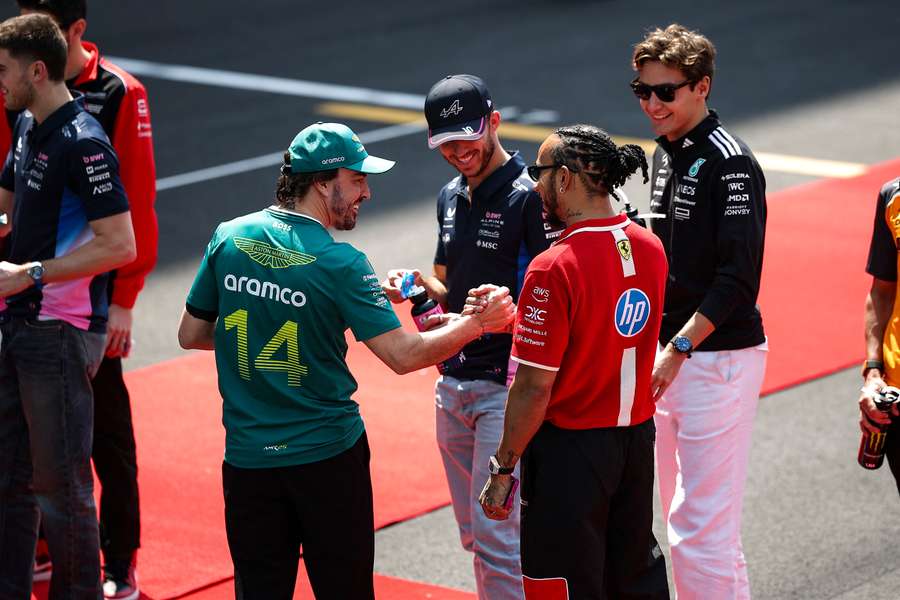 Alonso (I) choca la mano con Hamilton (D)