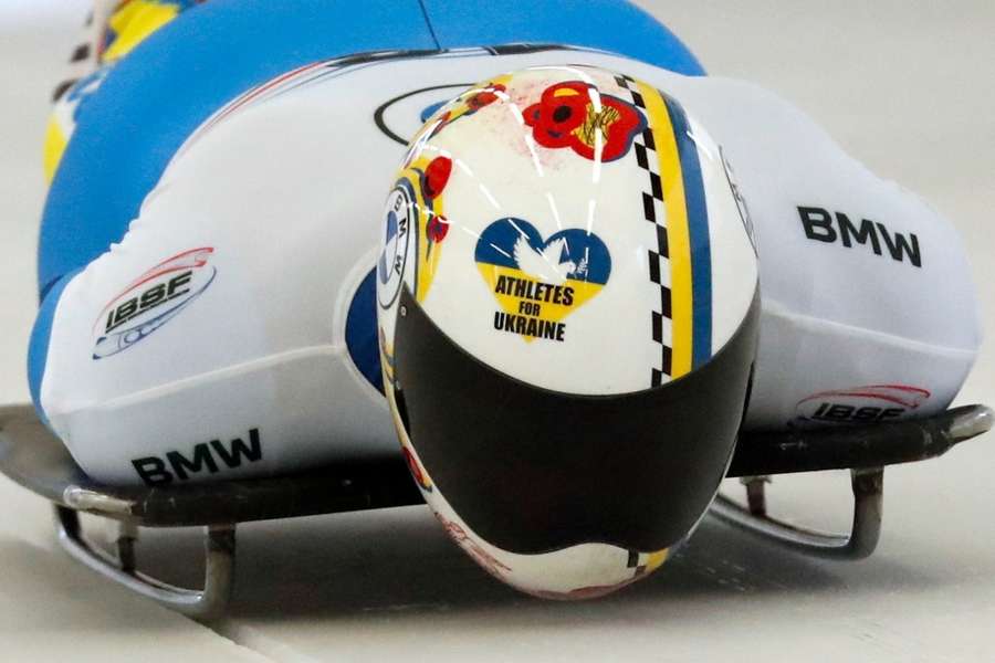 Skeletonracer Vladyslav Heraskevych in actie met een "Athletes for Ukraine" helm