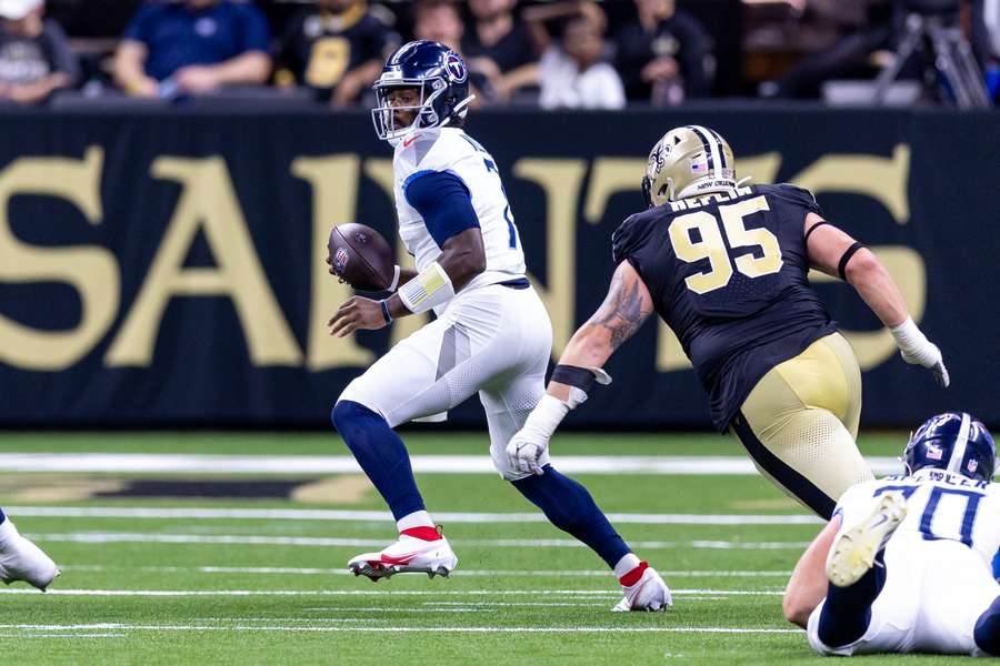 Tennessee Titans' quarterback Malik Willis bliver jagtet af New Orleans Saints' defensive tackle Jack Heflin.