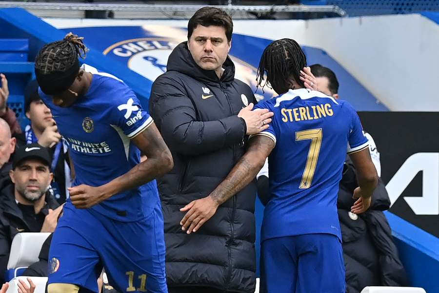 Chelsea boss Mauricio Pochettino consoles Raheem Sterling (R) as he leaves the pitch