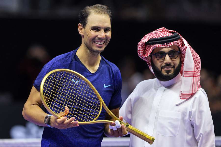 Rafael Nadal receives a golden racquet from Saudi Arabia's General Entertainment Chairman Turki al-Sheikh after competing in the 'Six Kings Slam'