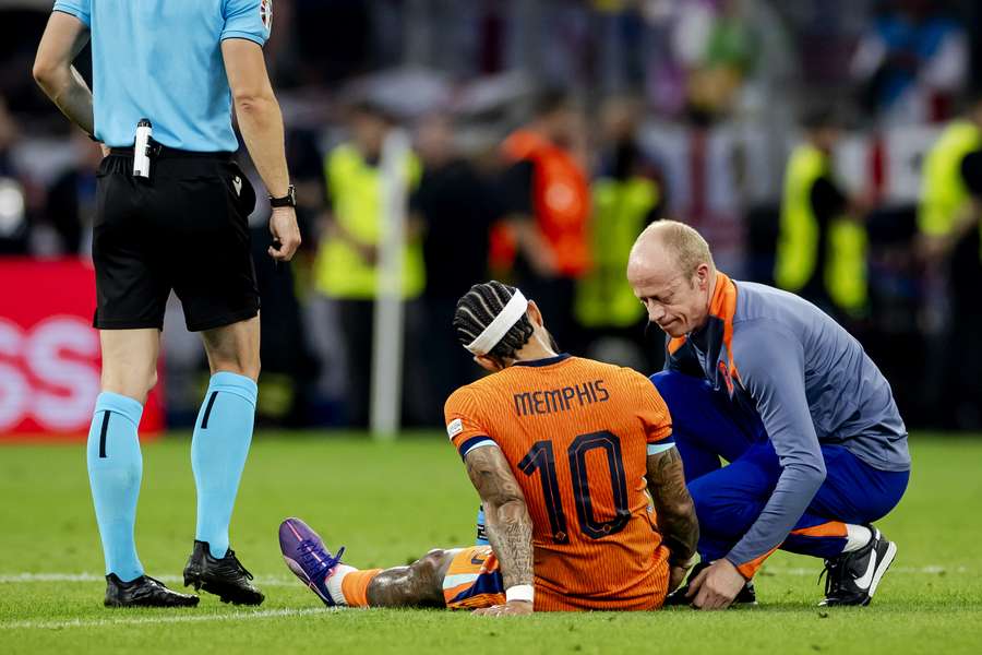 Memphis Depay zit geblesseerd op de grasmat