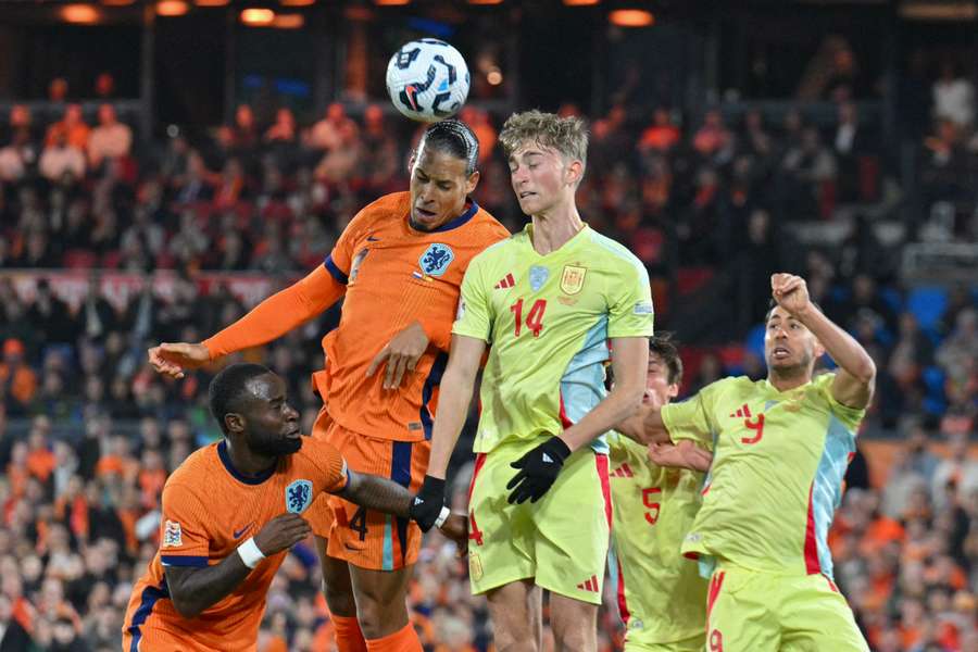 Netherlands' defender Virgil van Dijk (left) and Spain's Dean Huijsen jump for the ball