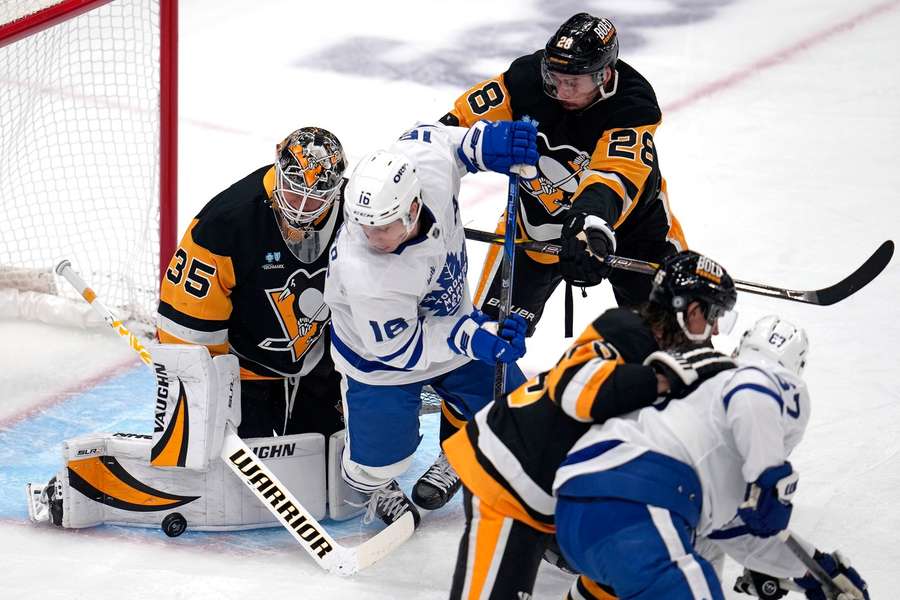 Toronto Maple Leafs' Mitch Marner is defended by Pittsburgh Penguins' Marcus Pettersson in front of goaltender Tristan Jarry