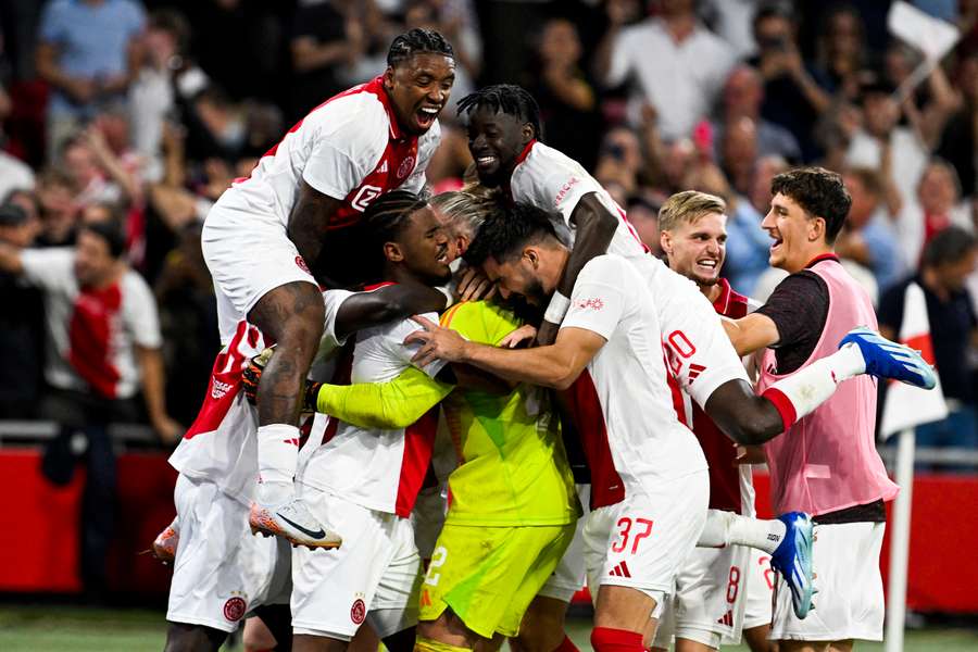 Ajax's players celebrate after winning the penalty shootout