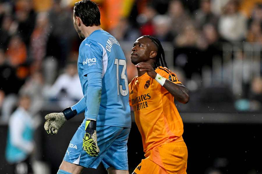 Real Madrid's Vinicius Junior clashes with Valencia's Stole Dimitrievski before he is shown a red card