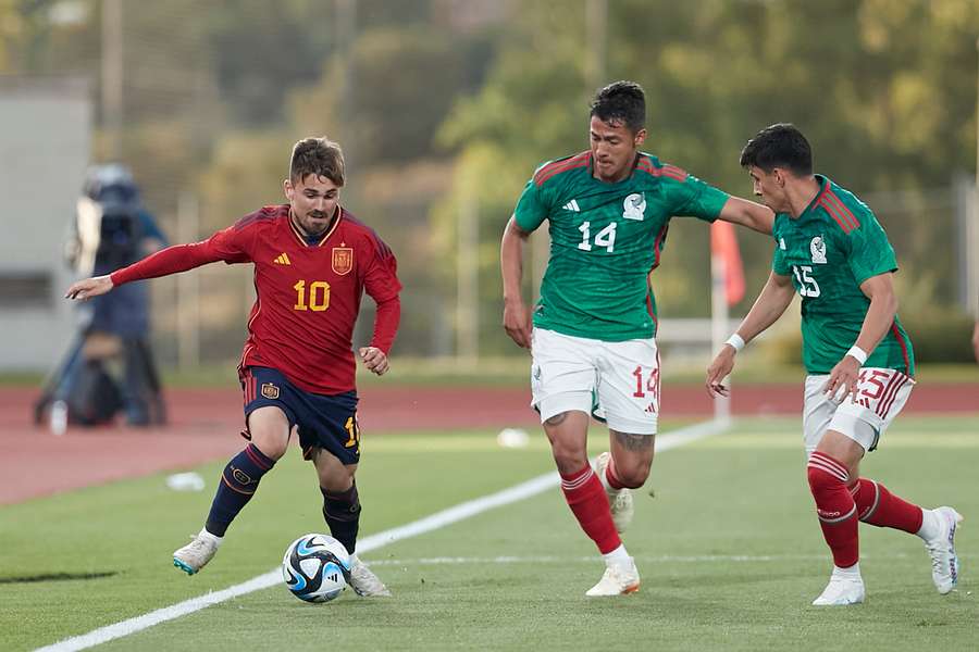 Rodri conduce la bola ante dos jugadores mexicanos