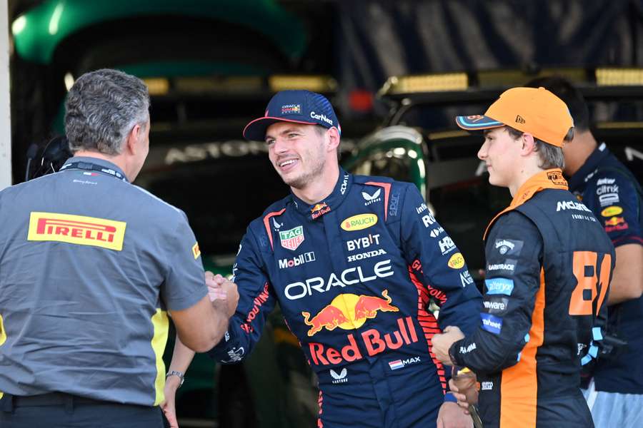 Red Bull's Max Verstappen (C) celebrates his poll position as second-placed McLaren's Oscar Piastri (R) looks on