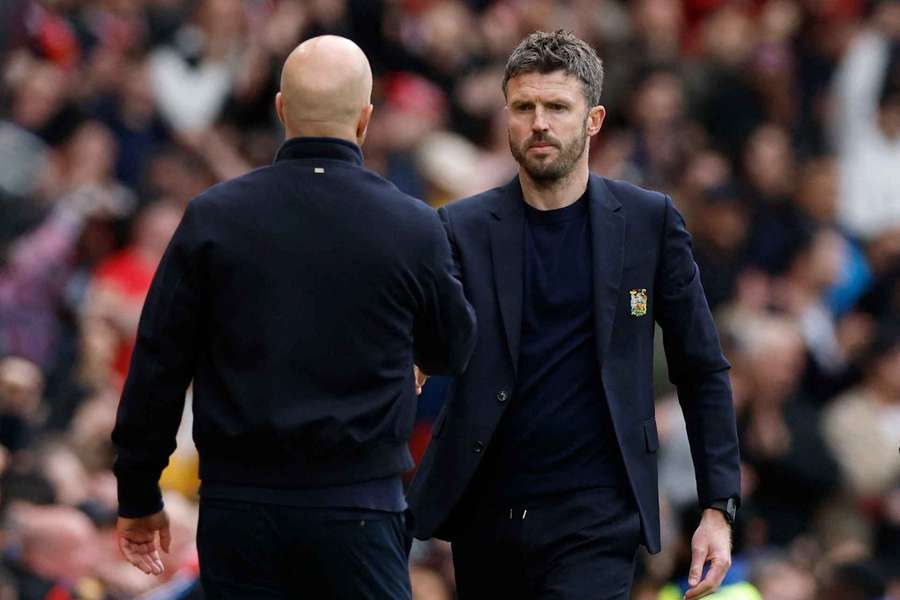 Carrick si podáva ruky so Slotom.