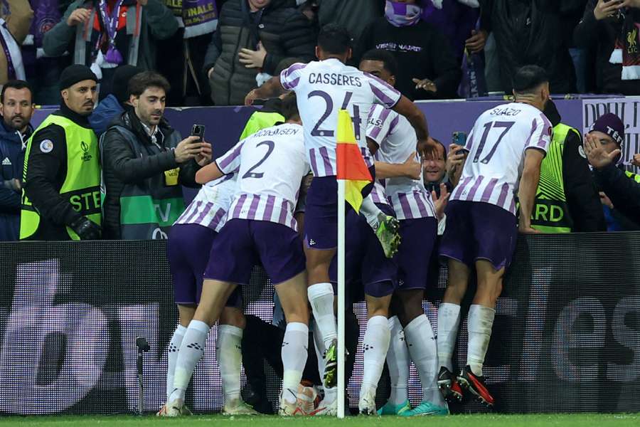 Toulouse players celebrate scoring their second goal against Liverpool