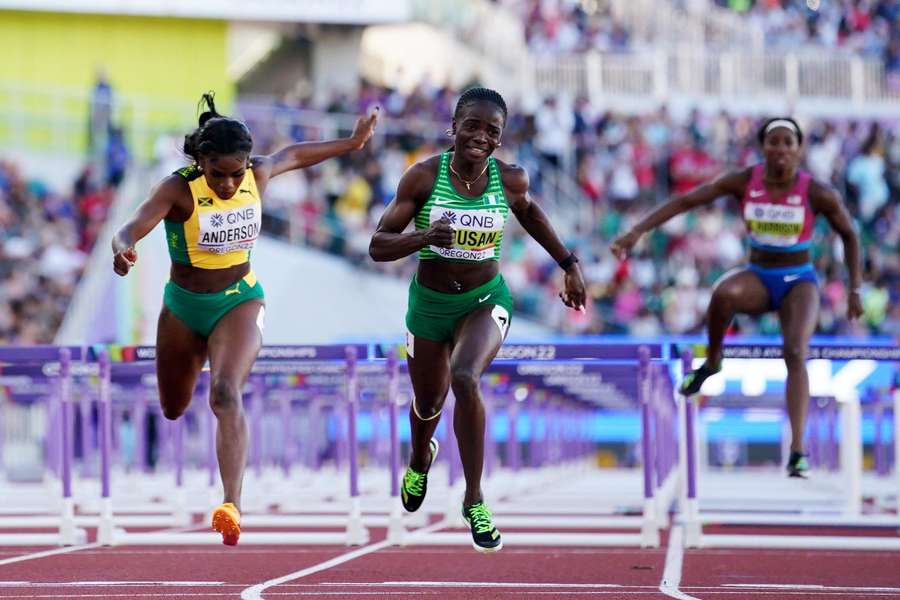 Toni Amusan, centre, used the long distance shoes in the final of the 100m hurdles and won gold