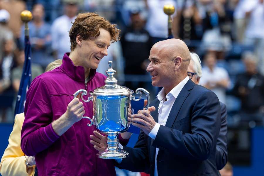 Jannik Sinner was presented with the trophy by Andre Agassi