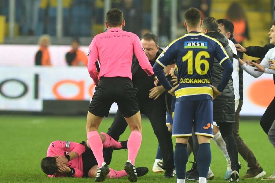 Halil Umut Meler drops to the floor after being punched